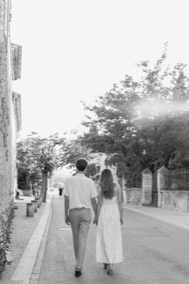 couple qui se promène main dans la main dans un village de Provence avant leur mariage